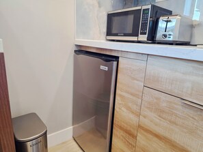 A compact kitchen with a microwave, toaster, and dishwasher.