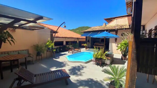 A backyard with a swimming pool, lounge chairs, and potted plants. - Flamboyant Space - Armação dos Búzios - Near the Beach (Armação dos Búzios)
