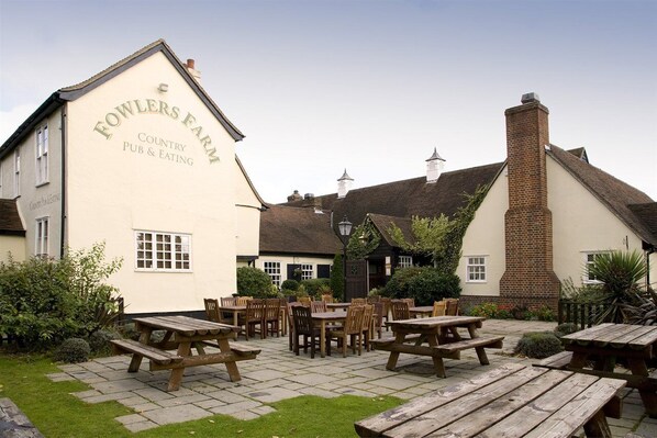 A traditional country pub with outdoor seating and a brick chimney. - Premier Inn Braintree (Braintree)