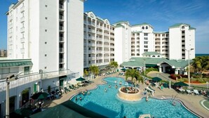 Un hotel con varias edificaciones blancas, un área de piscina central y asientos al aire libre.