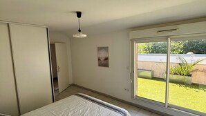 Une chambre à coucher comprenant un lit, une armoire, une porte, un luminaire au plafond, une fenêtre et une vue sur l’extérieur.
