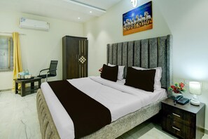 Ein Hotelzimmer mit Bett, Nachttisch und einem Bild an der Wand.