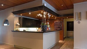 Une cuisine moderne dotée d’un îlot central, d’un plafond en bois et d’une bibliothèque intégrée.