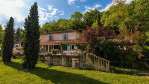 A traditional house with a tiled roof, surrounded by lush greenery and a stone wall. - Suite room with private shower and separate toilet (Auch)