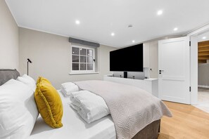 Ein modernes Schlafzimmer mit Bett, Fernseher und Bad.