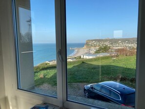 A coastal view through a window with a car parked outside. - The Corniche and its panoramic view (Fécamp)