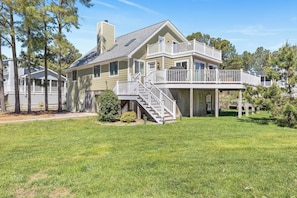 A two-story house with a covered porch, a staircase leading to the upper level, and a fenced yard. - Lake View Drive House (Bethany Beach)
