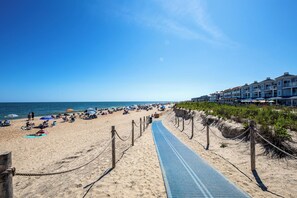 A beach with a pathway leading to a building with multiple balconies. - Lake View Drive House (Bethany Beach)