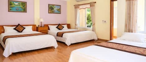 Habitación de hotel con dos camas, una ventana con cortinas, un cuadro en la pared y un equipo de aire acondicionado.