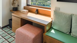 A room with a desk, a green sofa, a window with a view, and a mounted television. - Villa Meridia (Massa Lubrense)