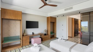 A modern hotel room with a bed, a desk, a chair, a television, and a ceiling fan. - Villa Meridia (Massa Lubrense)