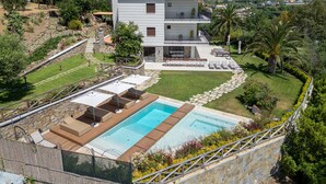 A modern two-story house with a swimming pool, outdoor seating, and a view of the surrounding landscape. - Villa Meridia (Massa Lubrense)