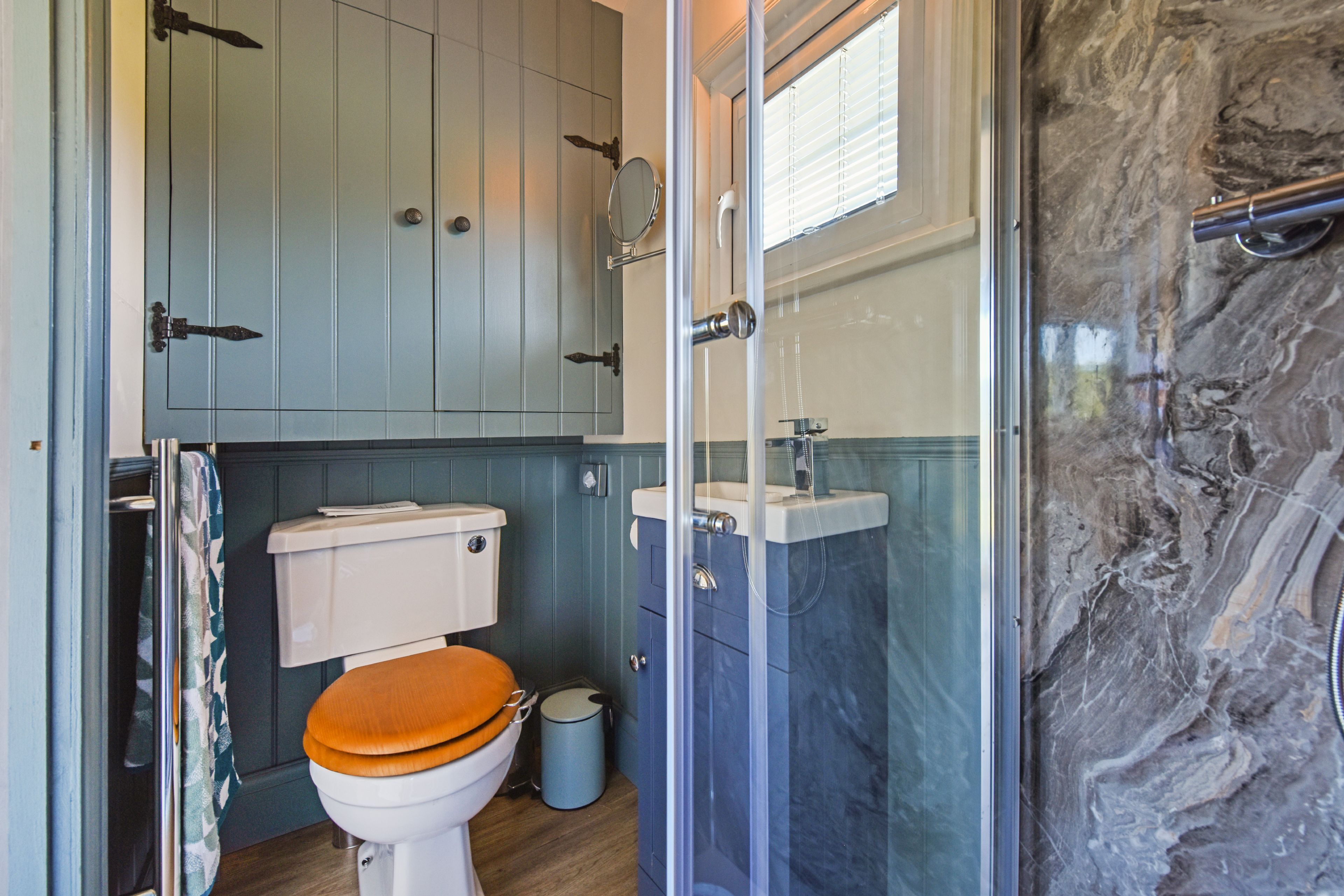 A bathroom with a toilet, sink, and shower.
