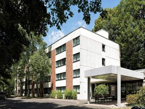Un bâtiment moderne doté d’une entrée abritée, de grandes fenêtres et d’un espace de stationnement.