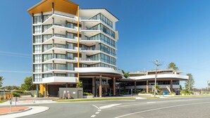 Ein mehrstöckiges Hotel mit geschwungener Eingangspartie, Balkonen und modernem Architekturstil.