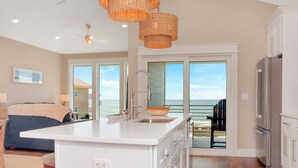 A modern kitchen with a large island, stainless steel appliances, and a view to the ocean. - ☀️ Short Walk to Beach - Amazing Views - Sand Pearl ☀️ (St. Joe Beach)