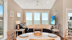 A dining area with a table, chairs, and a view of the ocean. - ☀️ Short Walk to Beach - Amazing Views - Sand Pearl ☀️ (St. Joe Beach)