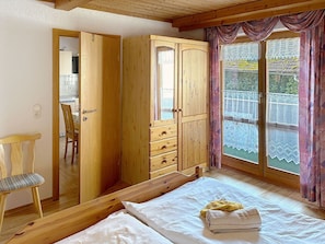 Ein Zimmer mit einem Bett, einem Holzschrank und einem Stuhl.