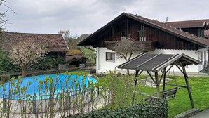 Un chalet traditionnel doté d’une piscine, d’une terrasse en bois et d’un jardin.
