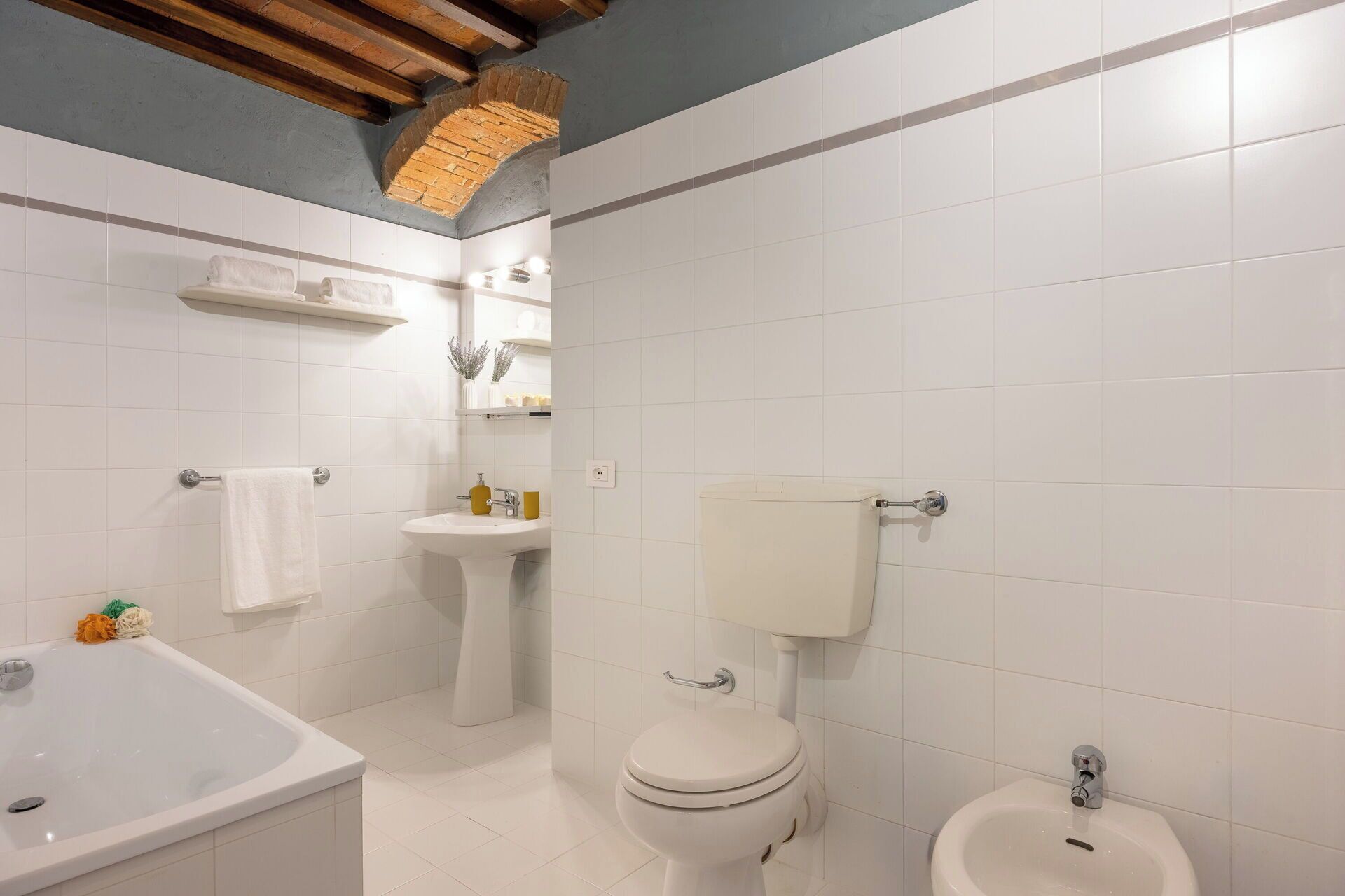 Un baño con lavamanos, inodoro, bidé y un espejo.