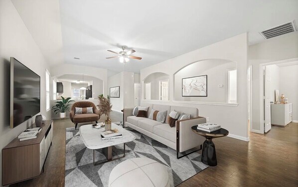A modern living room with a sofa, coffee table, and TV.