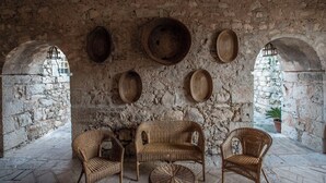 Un interno rustico con pareti in pietra, mobili in vimini e pavimento in pietra.