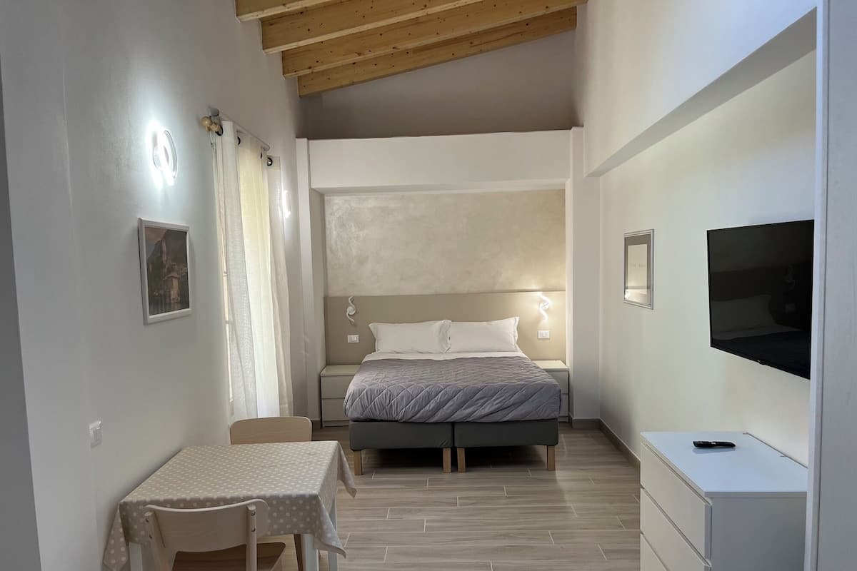 Ein Schlafzimmer mit einem Bett, einem Nachttisch und einem Fernseher.