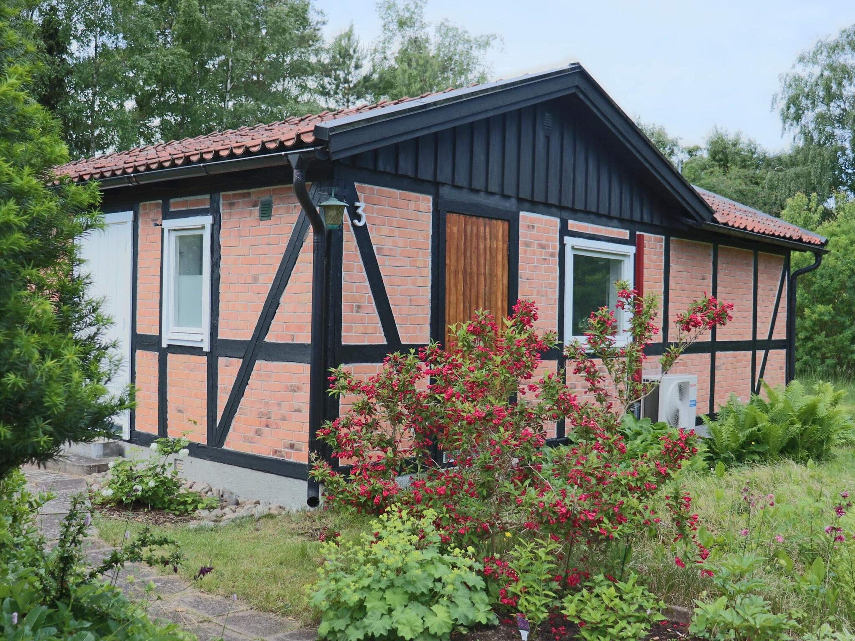 Een huis met twee verdiepingen, een bakstenen gevel en zwarte accenten.