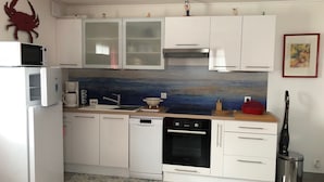 A modern kitchen with white cabinets, a microwave, a coffee maker, and a dishwasher. - Very comfortable single-storey house 2 minutes from the ocean on the island of Noirmoutier (L'EPINE)
