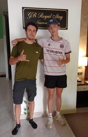 Two individuals standing in a room with a sign that reads 'GB Royal Stay Nuwara a'. - GB Royal Stay Nuwara Wewa (Anuradhapuraya)