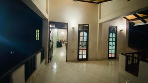 A spacious interior with a high ceiling, tiled flooring, and multiple doors leading to different rooms. - GB Royal Stay Nuwara Wewa (Anuradhapuraya)