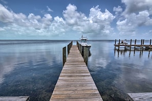 A wooden pier leading to a boat docked at a calm body of water. - 1 Mi to Pennekamp State Park! Family Home w/ Patio (Key Largo)