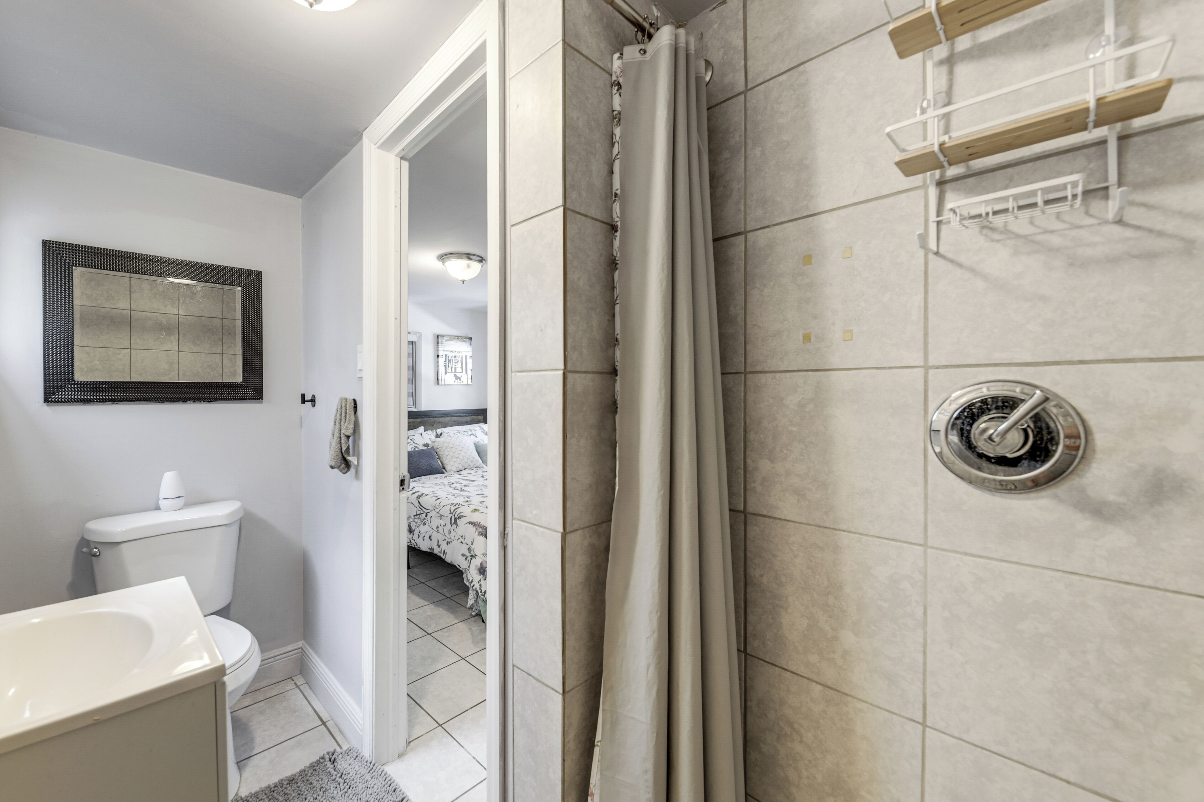Een badkamer met toilet, wastafel, douche en een handdoekrek.