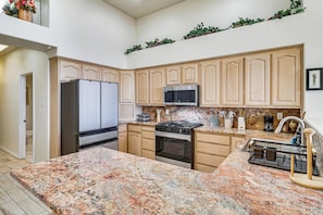 A kitchen with granite countertops, stainless steel appliances, wooden cabinets, and a built-in microwave. - ABQ Townhouse w/ Mtn-view Balcony: Pets Welcome! (Albuquerque)