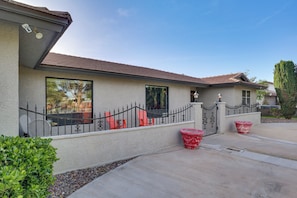 A house with a sloped roof, a balcony with a railing, and a driveway.