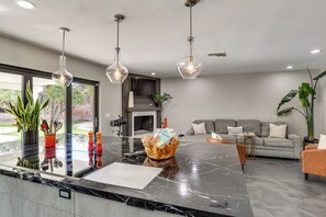 A modern kitchen with a marble countertop, pendant lights, and a large island. - Vegas Getaway w/ Extra-deep Pool, 5 Mi to Strip! (Las Vegas)