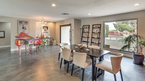 A spacious dining area with a large table and chairs, a piano, and a view through a large window. - Vegas Getaway w/ Extra-deep Pool, 5 Mi to Strip! (Las Vegas)