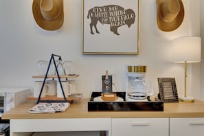A kitchen counter with a coffee maker, mugs, a milk jug, and a framed quote on the wall. - 1 Mi to OU! Sleek Guest House w/ Gas Grill (Norman)