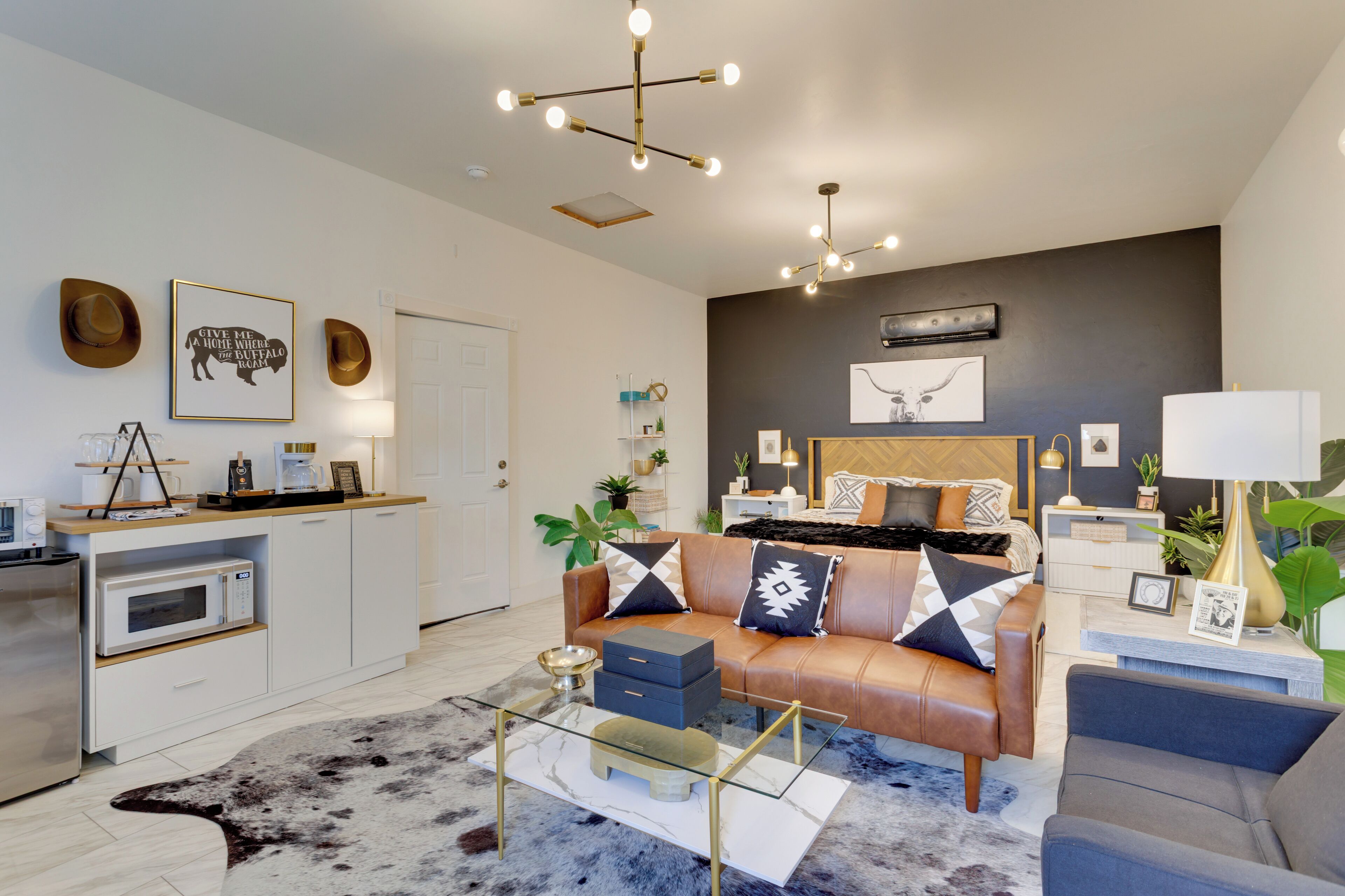 A modern living room with a sofa, coffee table, and a dining area with a microwave.