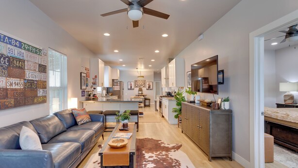 A modern living room with a leather sofa, a wooden coffee table, and a cowhide rug. - Walk to Norman Hot Spots: Family-friendly Home! (Norman)