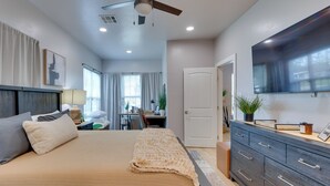 A bedroom with a bed, a dresser, a ceiling fan, a TV, and a desk with a chair. - Walk to Norman Hot Spots: Family-friendly Home! (Norman)