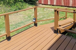 Eine Holzterrasse mit Geländern und einer Laterne.