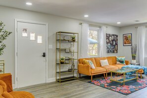 A living room with a sofa, coffee table, and a decorative shelf.