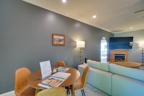 A modern living room with a dining table, chairs, a sofa, a fireplace, and a television. - 4 Mi to Dale Hollow Lake! Countryside Retreat (Byrdstown)