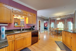 A kitchen with wooden cabinets, a dishwasher, and a countertop. - 4 Mi to Dale Hollow Lake! Countryside Retreat (Byrdstown)