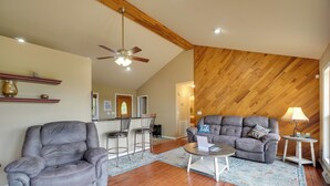 Ein Wohnzimmer mit grauem Sofa, Relaxsessel, Couchtisch und Holzboden.