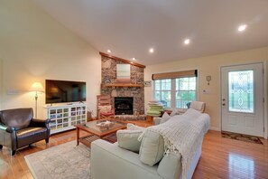 A living room with a stone fireplace, a television, a sofa, and a coffee table. - Bring Your Boat! 'all Decked Out' Byrdstown Home (Byrdstown)