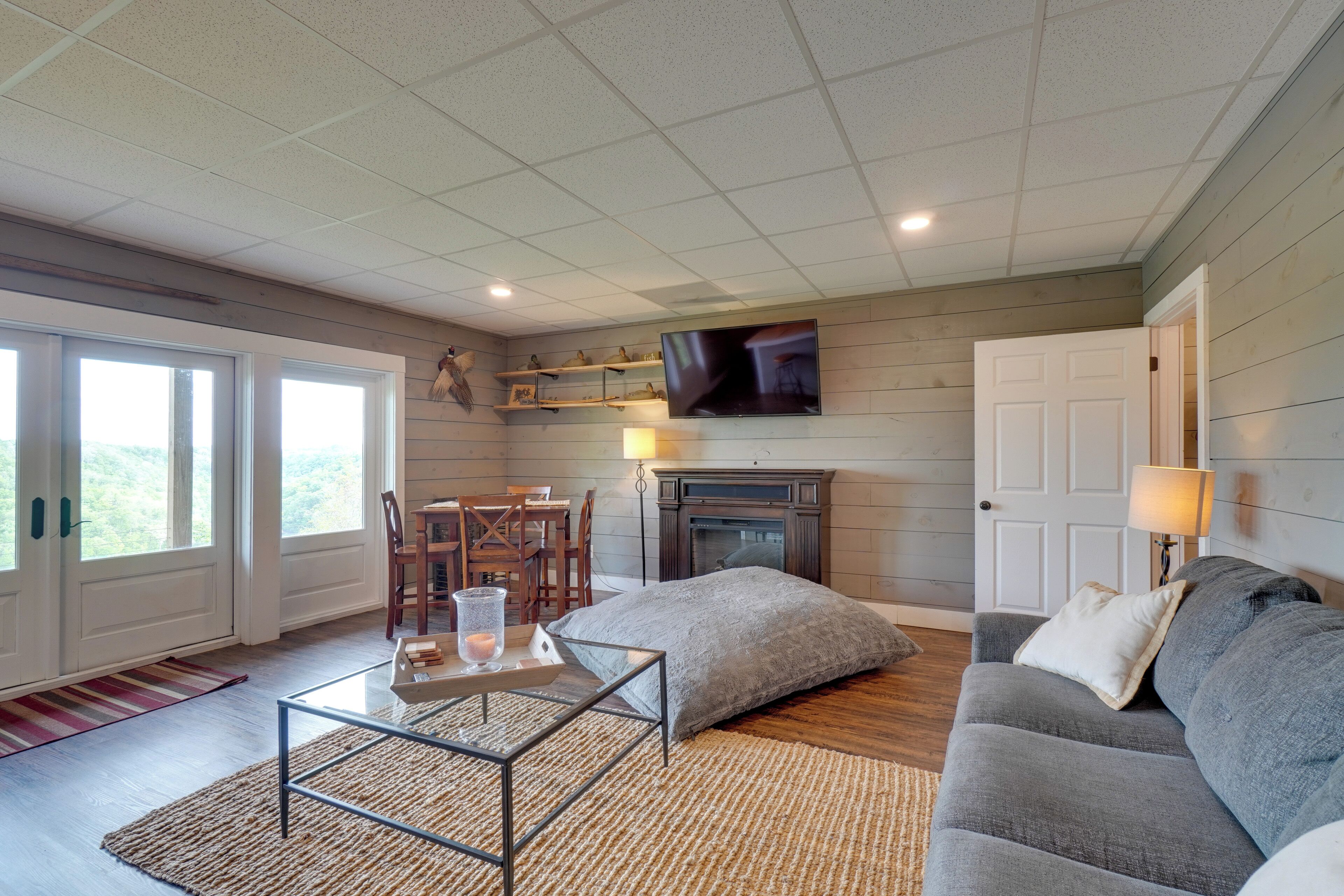 A living room with a fireplace, a sofa, a coffee table, and a TV mounted on the wall.