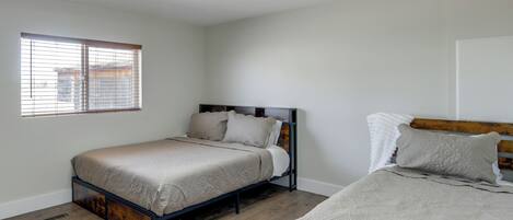 A bedroom with a bed, a window, and a ceiling fan.