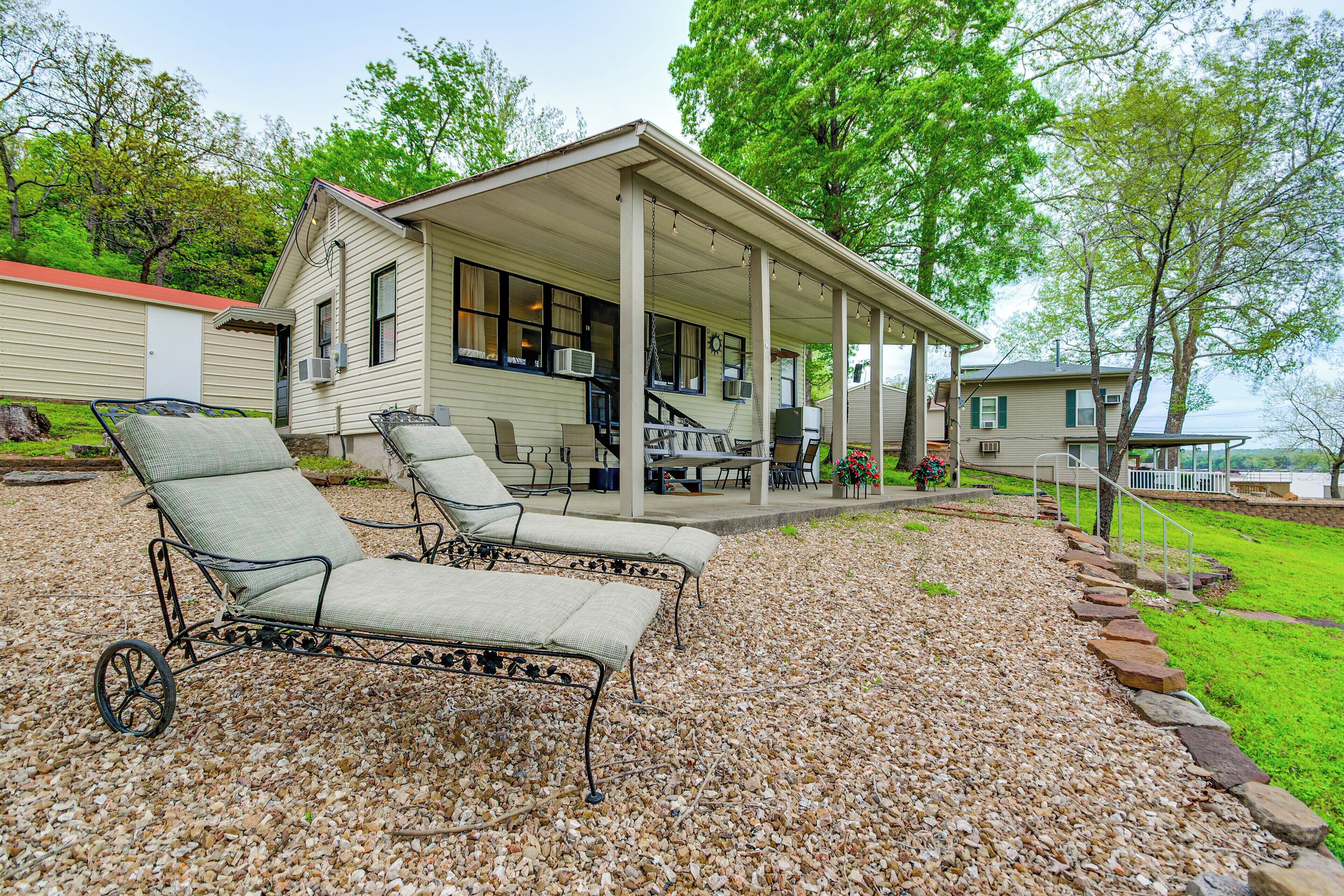 A covered patio with outdoor furniture, a covered deck, and a view of a lake.